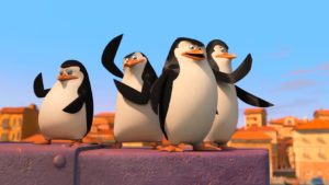i pinguini di madagascar sul tetto di un palazzo in una scena del film
